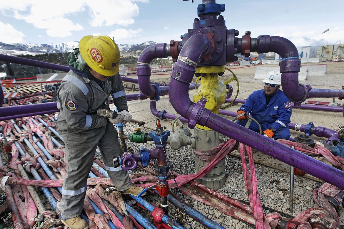 In this March 29, 2013, file photo, workers tend to a well head during a hydraulic fracturing operation outside Rifle, in western Colorado. Interior Secretary Ryan Zinke announced plans Thursday to encourage oil and gas development on federal lands with faster and simpler permitting and more frequent sales of government drilling rights. (AP Photo/Brennan Linsley, File)