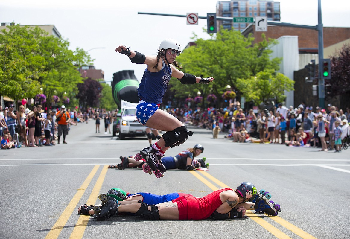 LOREN BENOIT/PressSamantha Houseman, also known as Seymour Guts, does a trick over fellow Snake Pit Derby dames during the July Fourth parade on Tuesday.