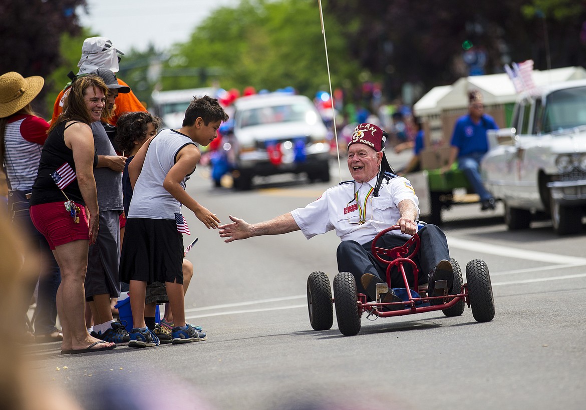 LOREN BENOIT/PressLegion of Honor member Bob Green gives of high-fives as he drives his go kart down the July Fourth Hometown Heroes Parade route.