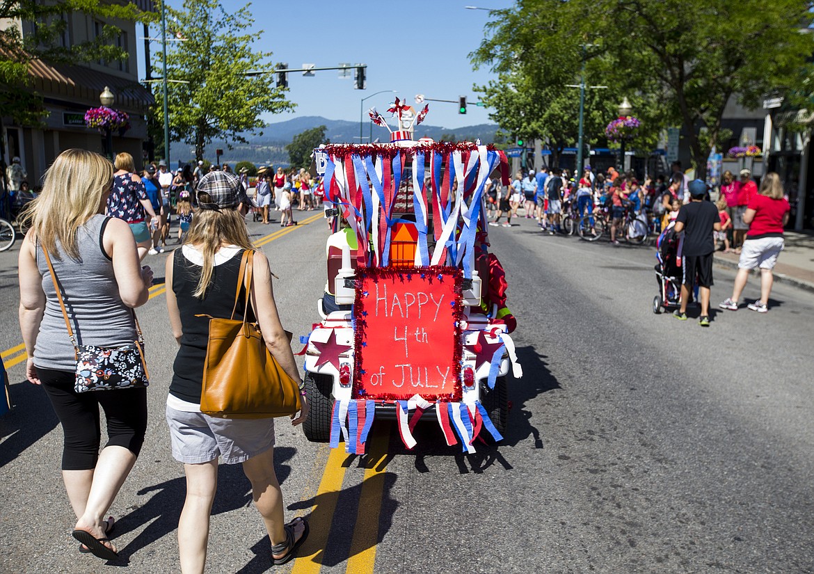 LOREN BENOIT/PressA golf cart decked out in red, white and blue streamers heads down Sherman Avenue during the July Kiddies Parade on Monday.