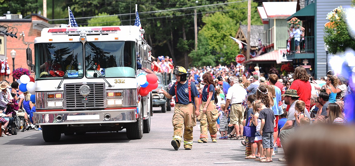 Bigfork Firefighters wave to the crowds as they make their way through the Bigfork Fourth of July Parade on Tuesday afternoon, July 4. (Brenda Ahearn/Daily Inter Lake)