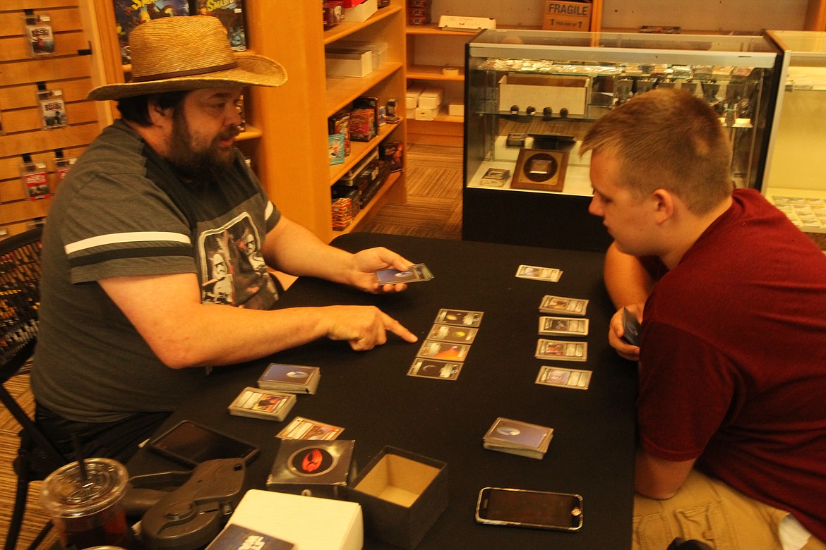 Mitchell Bonds/Press
Store co-owner Logan Knight, left, teaches Jaykob Senninger how to play &#147;Star Trek: The Customizable Card Game&#148; at Knowhere Comics, Coffee and Games in Post Falls on Sunday.