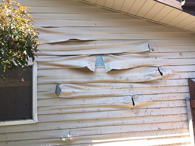 Bob Kirkpatrick/The Sun Tribune - Siding on the exterior garage wall of the Dan Lynch home on the westside of Logan's house melted under intense heat.