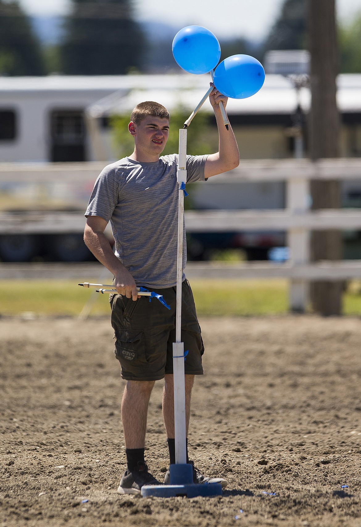 Hunter Ranney places a balloon on a stick during the Idaho State Shoot on Friday at the Kootenai County Fairgrounds.