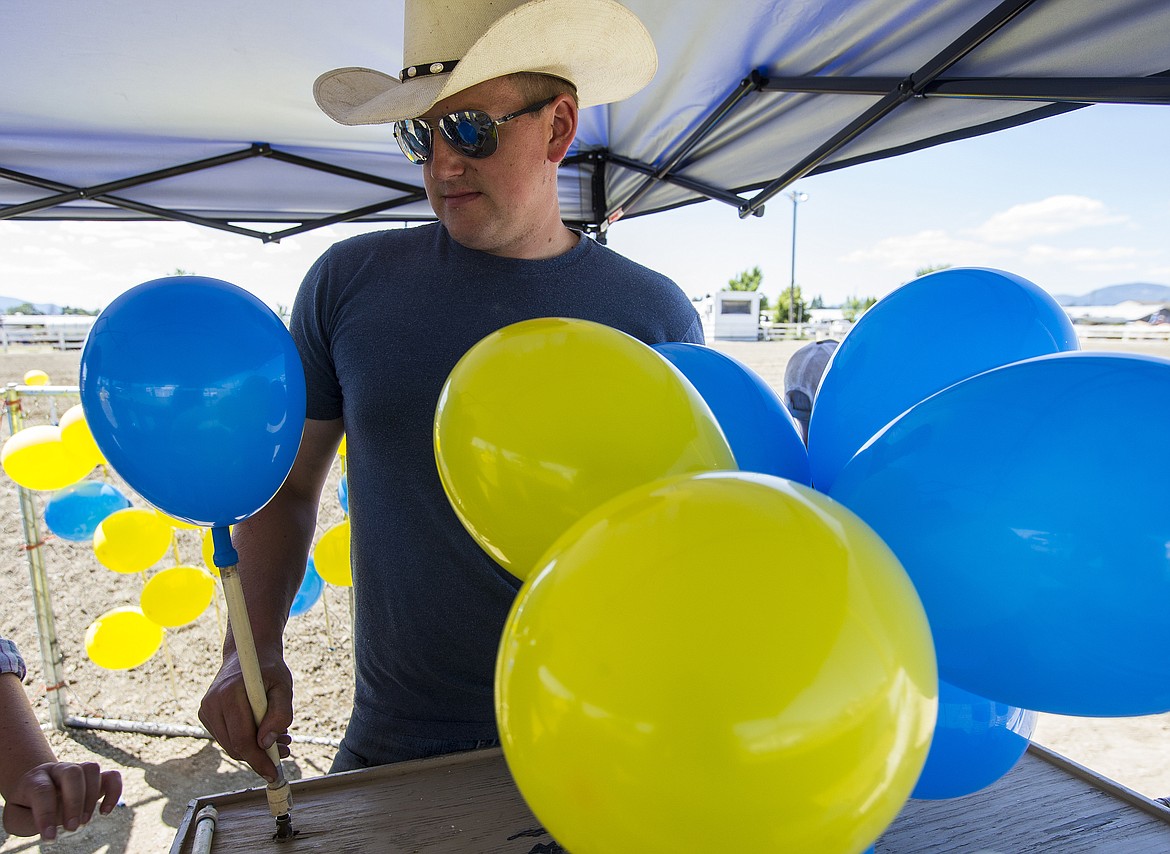 LOREN BENOIT/PressTyler Burnett blows up mounted shooting balloons Friday afternoon at the Kootenai County Fairgrounds. Burnett and others went through 1,500 balloons on Friday.