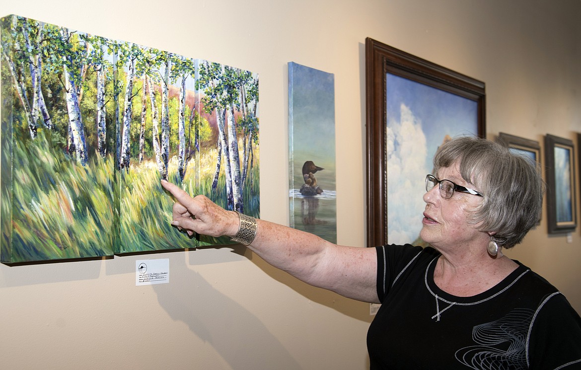 Juanita Small Salmon explains the Tripych technique of painting in which three separate paintings are created in such a way that they can stand alone or stand together as a single work. (Marla Hall/Lake County Leader)