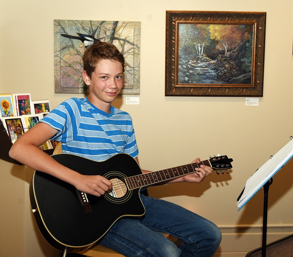 Thirteen-year-old Noah Carlson from Ronan entertained the art enthusiasts attending the opening. (Marla Hall/Lake County Leader)