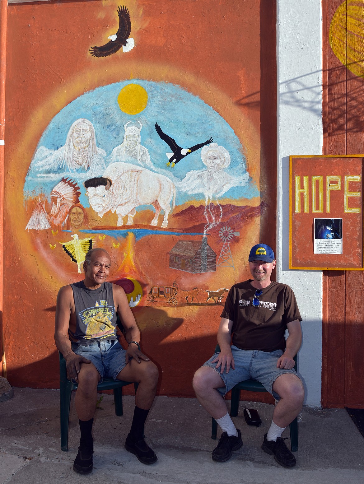 Ken Camel and Jason Moore take a few minutes to relax in front of a mural by Camel at the HUB on Polson&#146;s Main Street. (Marla Hall/Lake County Leader)