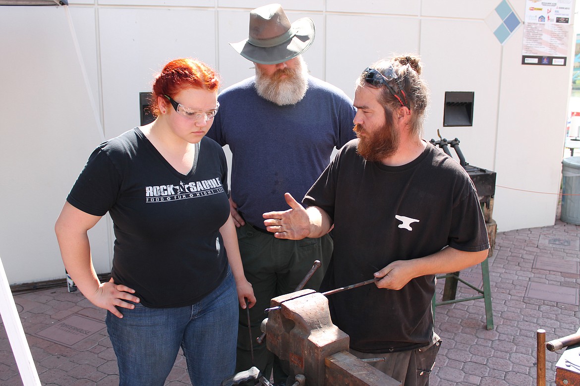 Charles H. Featherstone/Columbia Basin Herald
Blacksmith Kyle Leslie gives apprentice Caitlyn Turner some pointers on working iron while Caitlyn&#146;s father, George, looks on, during the blacksmith display at Freedom Fest in McCosh Park on Saturday.