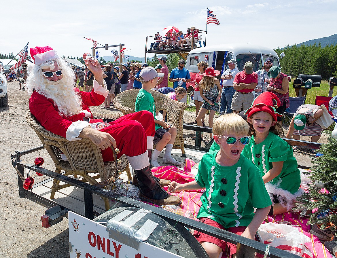 Santa Claus waves to the crowd as his &#147;elves&#148; throw out candy at the Polebridge Fourth of July parade Tuesday. (Chris Peterson photo)