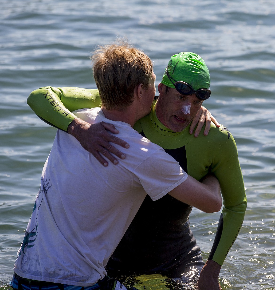 LOREN BENOIT/PressGage Neirinckx helps his father, Peter, out of the water Monday afternoon at Independence Point. Peter swam more than 18 miles from Harrison to Coeur d'Alene to celebrate his 50th birthday on Monday.