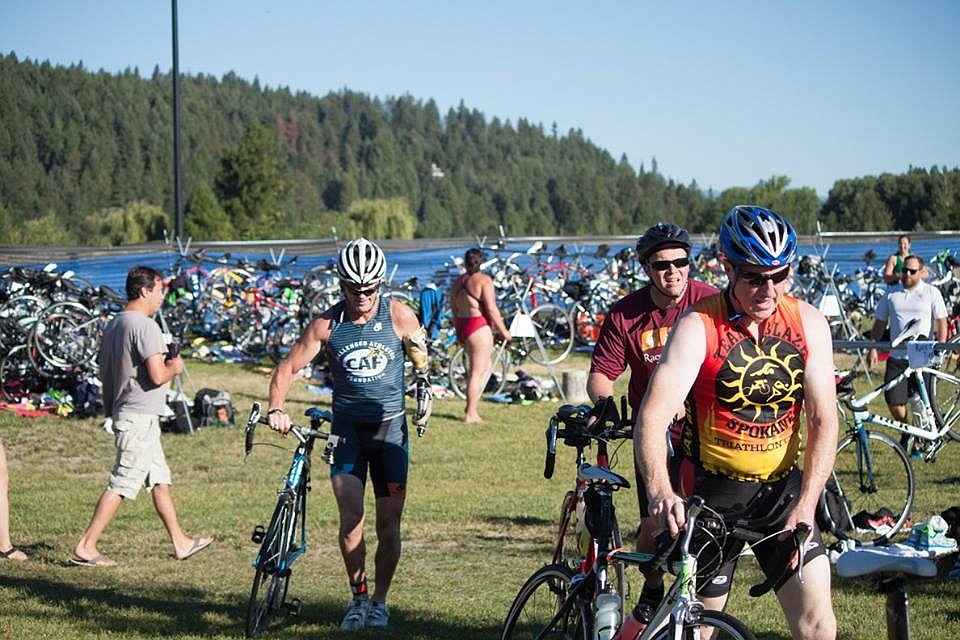 Triathletes transition from the swim to the cycling stages of the Race The River triathlon on July 23, 2015.