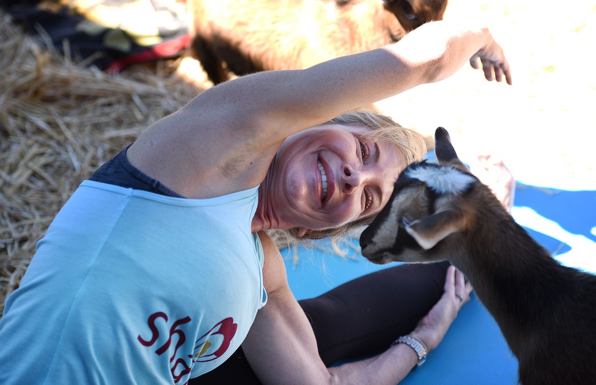 Yoga instructor Robin Goldberg smiles up at a baby goat as she gives instructions to the class participating in Goat Yoga on Sunday, June 25, at Flying Pig Farms north of Kalispell.(Brenda Ahearn/Daily Inter Lake)