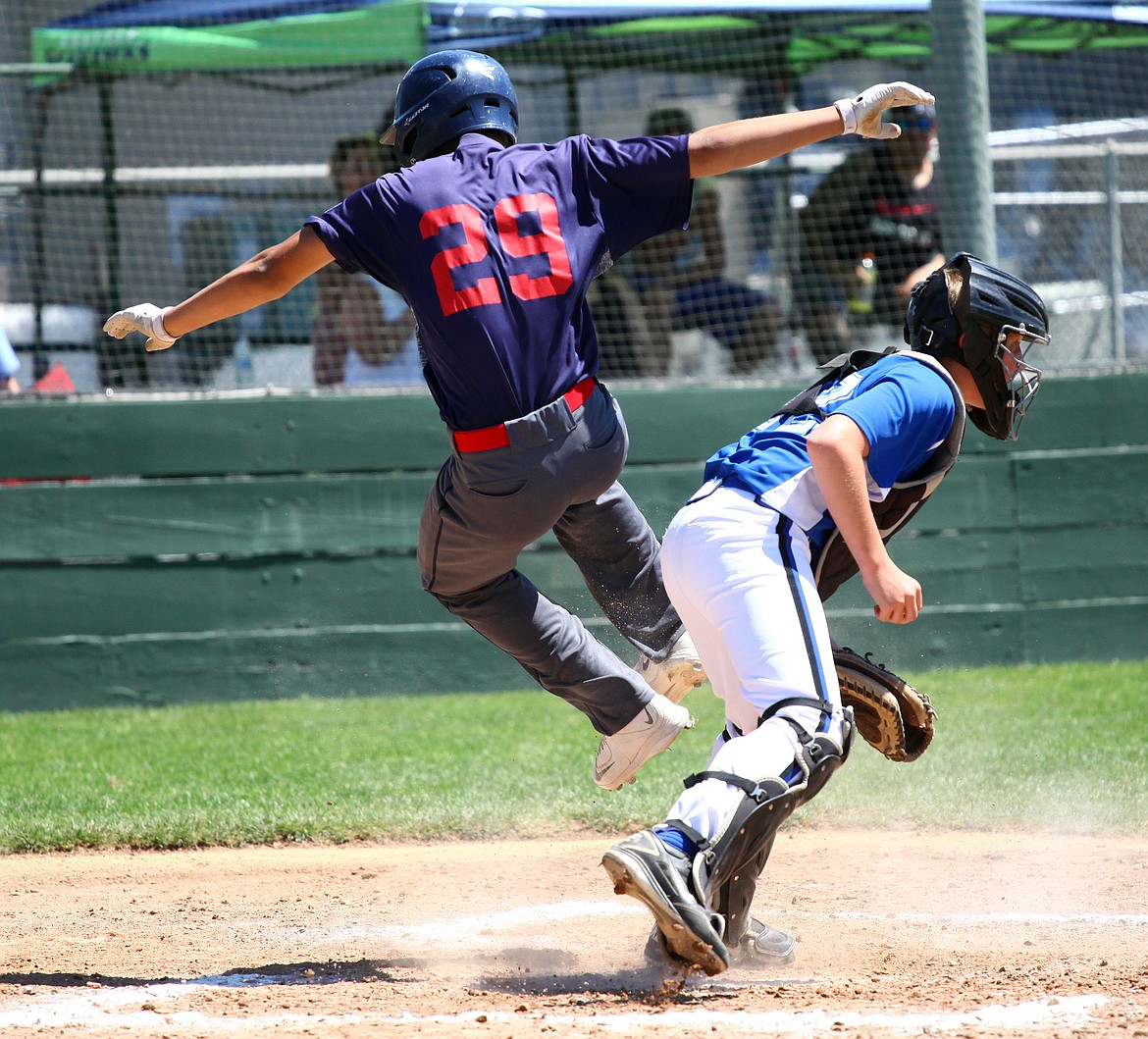 Rodney Harwood/Columbia Basin HeraldMoses Lake's Julian Egia is upended during a play at the plate during the North Washington 14-year-old Babe Ruth championship game on Friday at Johnson-O'Brien Stadium.