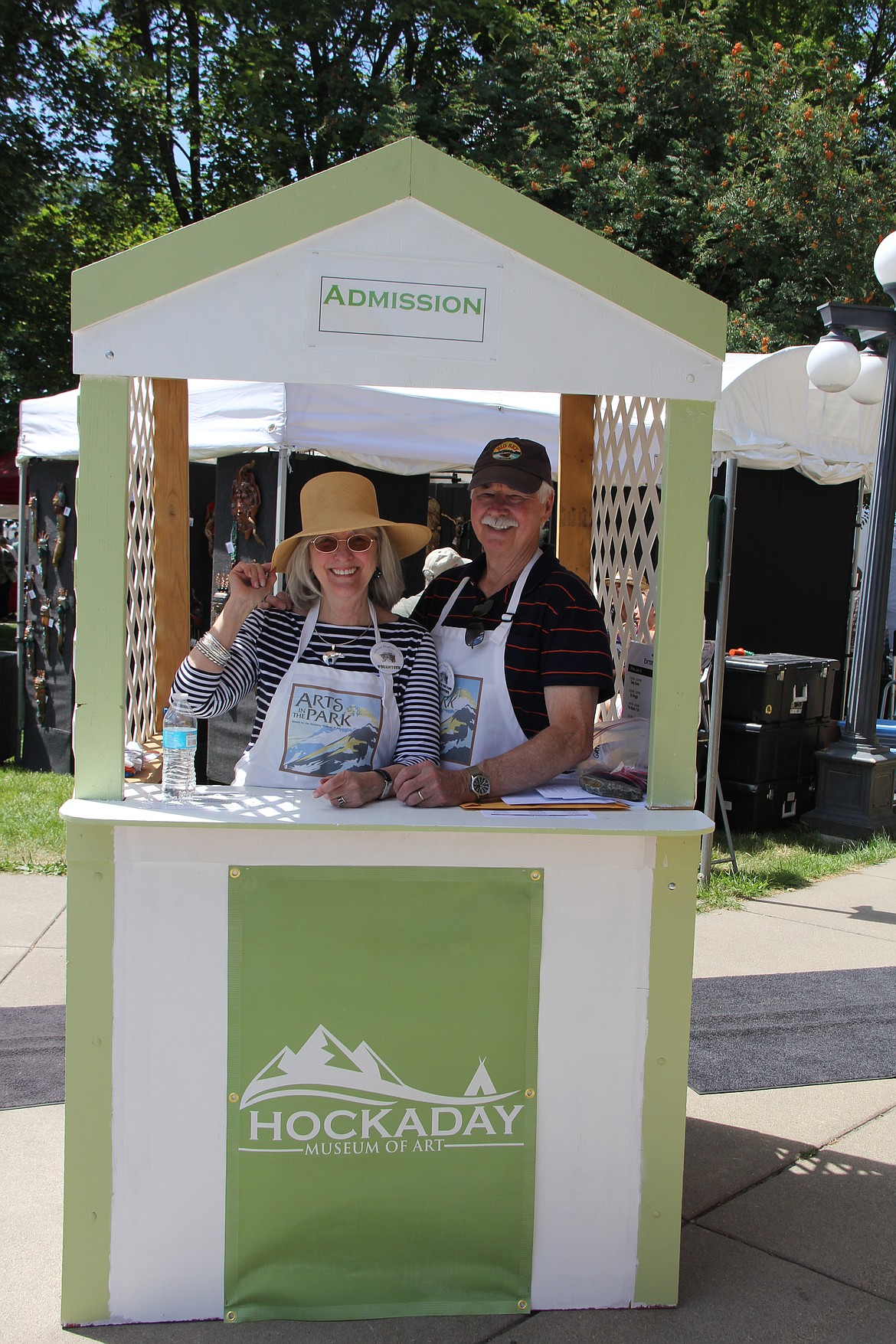 Museum members Margene and Alex Berry volunteer at the admissions gate at a previous Arts in the Park event. (Photo courtesy of the Hockaday Museum of Art)