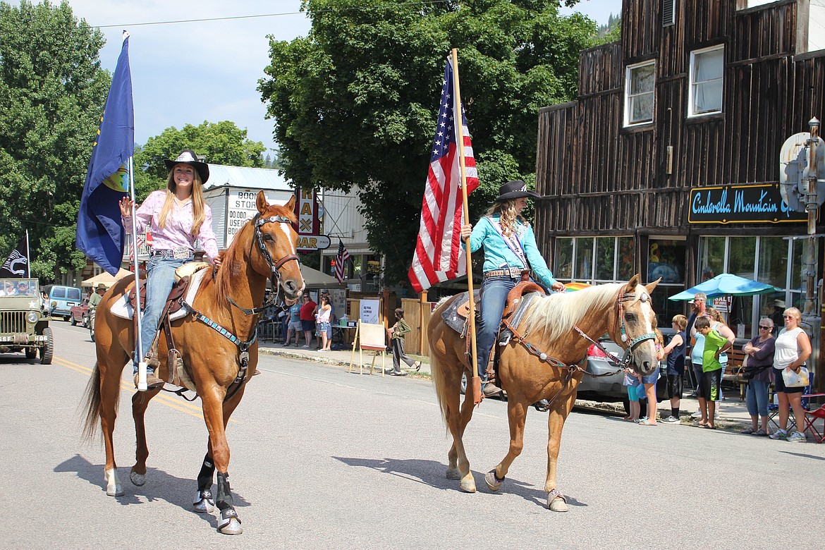 Rodeo Royalty Madison Hill and Joanna Warnken carry flags to lead the parade on Saturday.