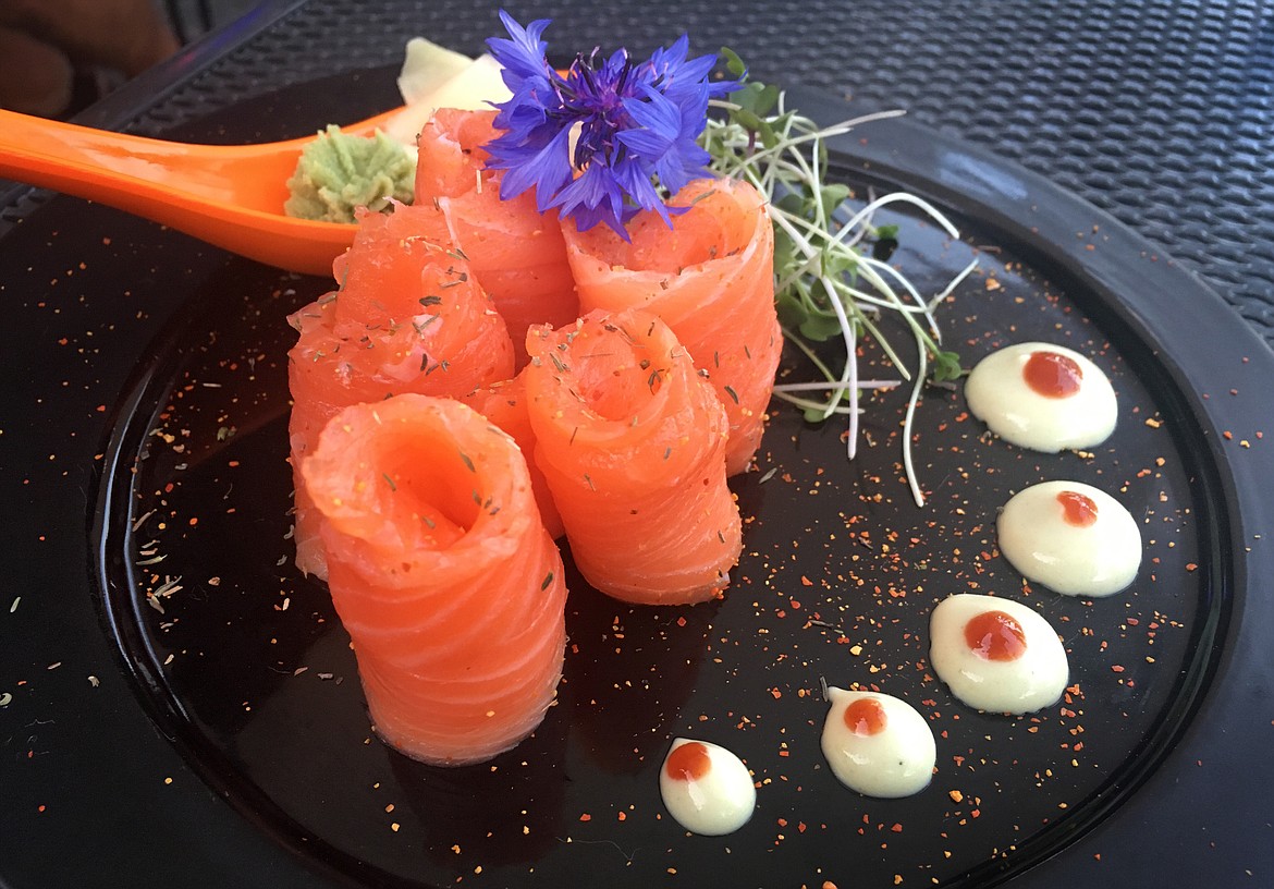 Salmon sashimi is served with a blend of spices and herbs, and topped with an edible flower at Indah Sushi.