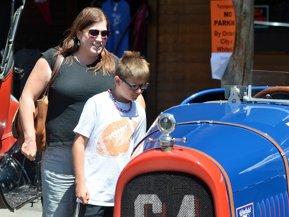 Avery Caton, 10, along with his mom Rayme Caton check out one of the Model Ts on Central Avenue Sunday afternoon during a Model T tour car show as part of the annual tour for the Model T Ford Club of America and the Model T Ford Club. (Heidi Desch/Whitefish Pilot)