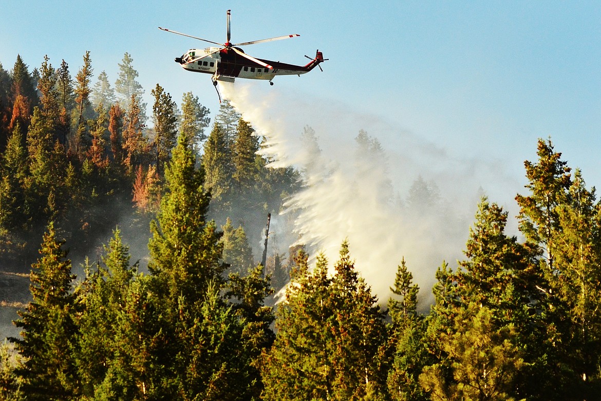 A TYPE 1 Helicopter puts an extra dowsing on the blaze at Lazier Creek Thursday. DNRC reports that the fire is now 70 percent contained after burning more than 1,100 acres. (Erin Jusseaume/Clark Fork Valley Press)