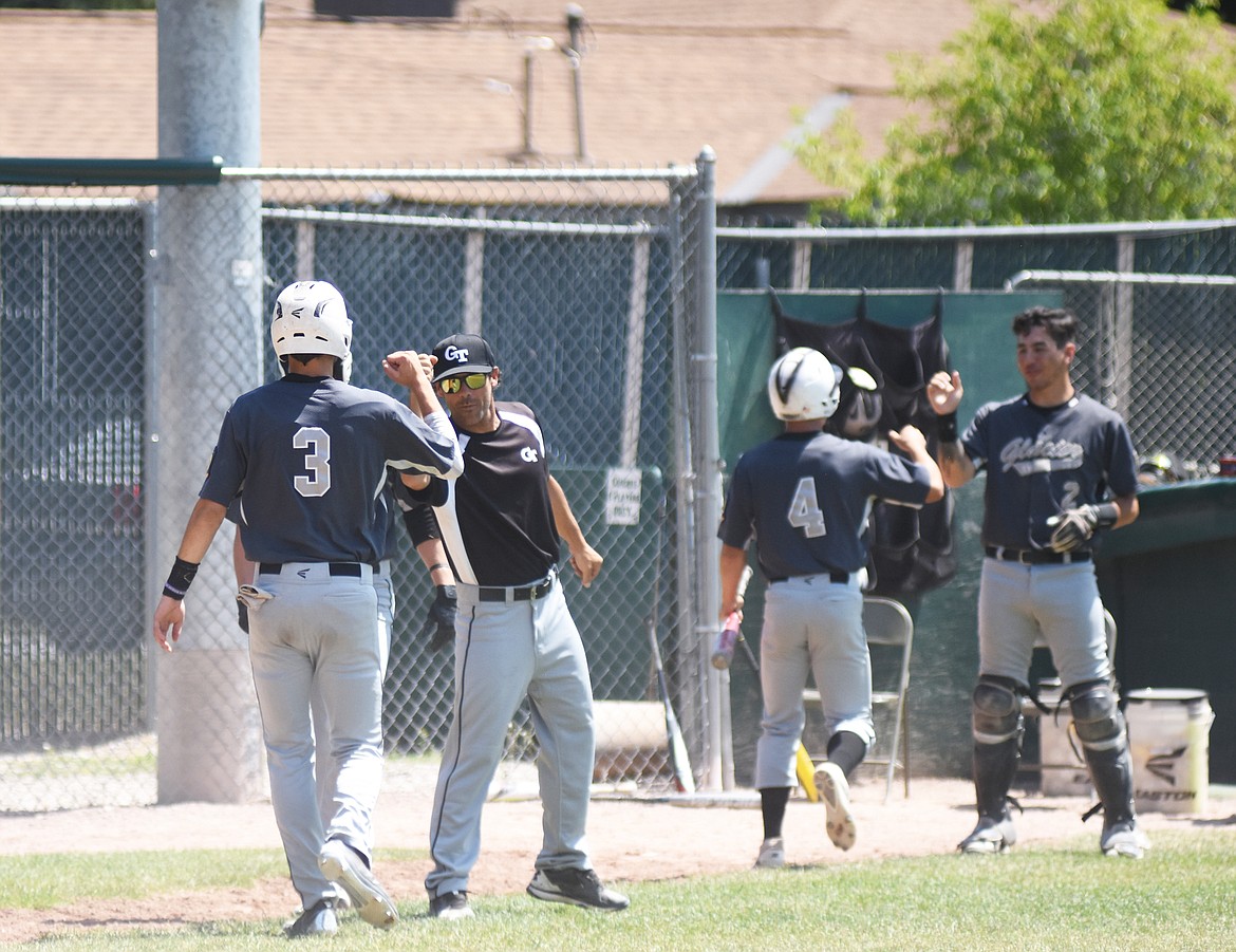 A group of Glacier Twins celebrate after a Coby Clark-Dickenson double sends two runs home Saturday against the Butte Miners.