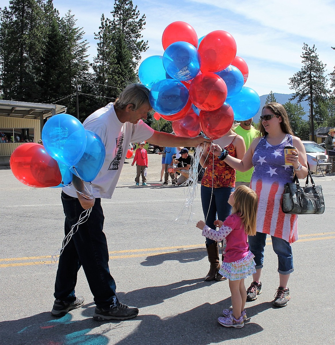 St. Regis Fire Chief Jerry Dockter hands out balloons to kids lining the parade route.