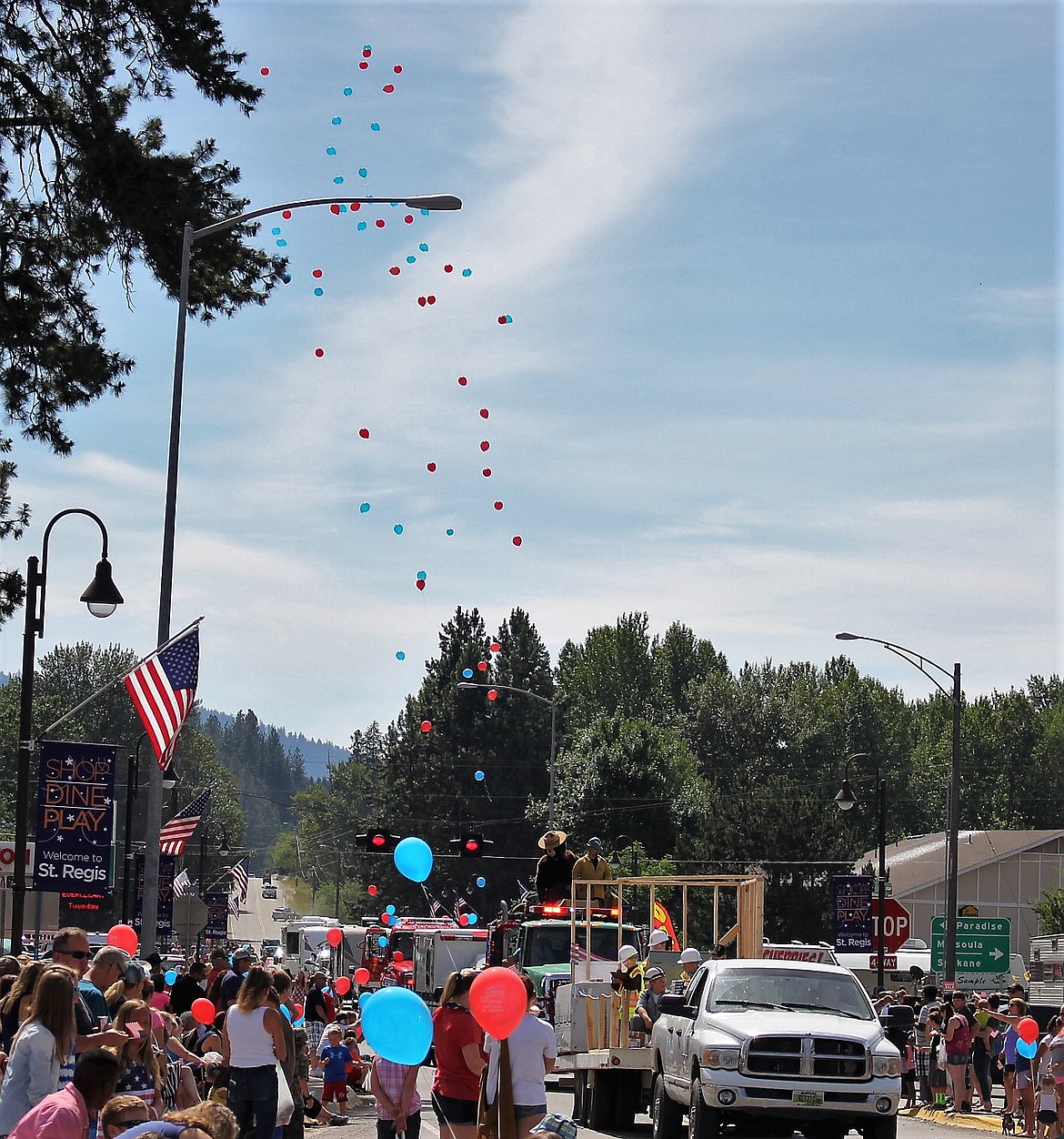 A string full of red and blue balloons fly high into the summer sky at the end of the parade.
