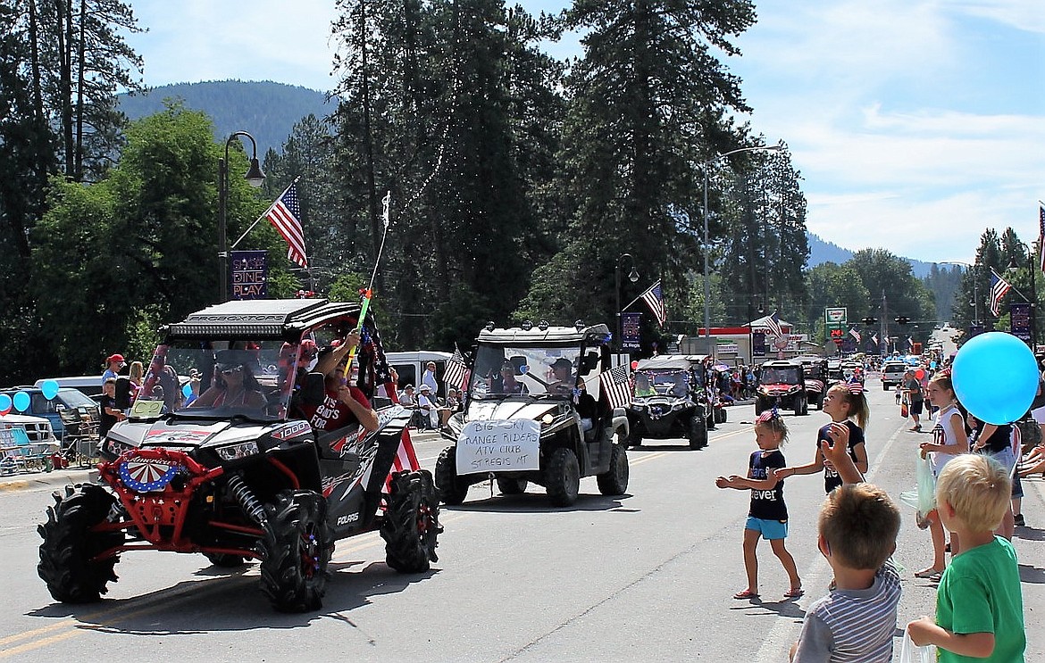 An ATV passes the crowd and cools them off with a squirt of water during the Fourth of July parade in St. Regis.