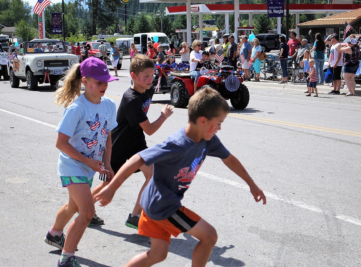 Kids scramble along the parade route picking up candy thrown by passing floats.