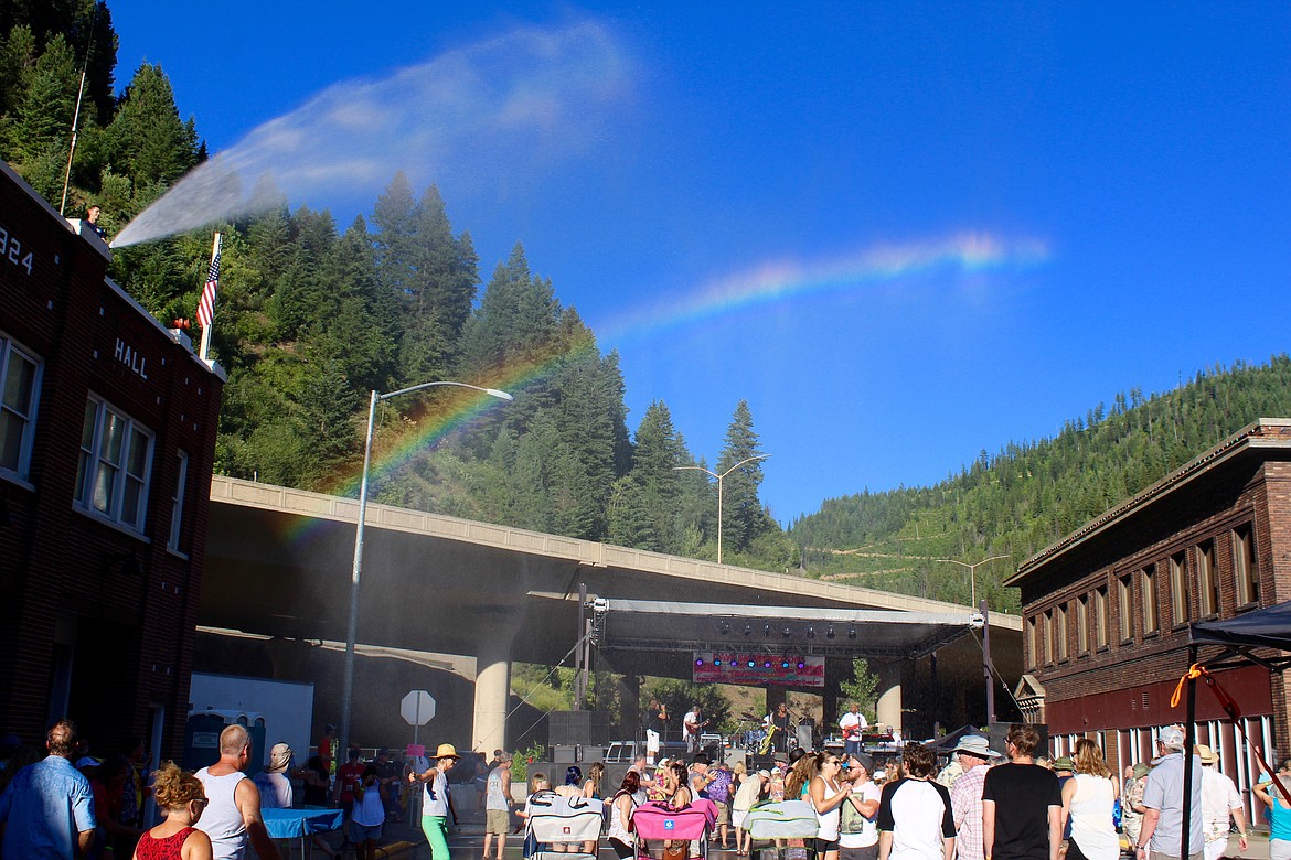 A rainbow forms over the main stage when crews from Shoshone County Fire District #1 help blues lovers beat-the-heat by breaking out the fire hose.