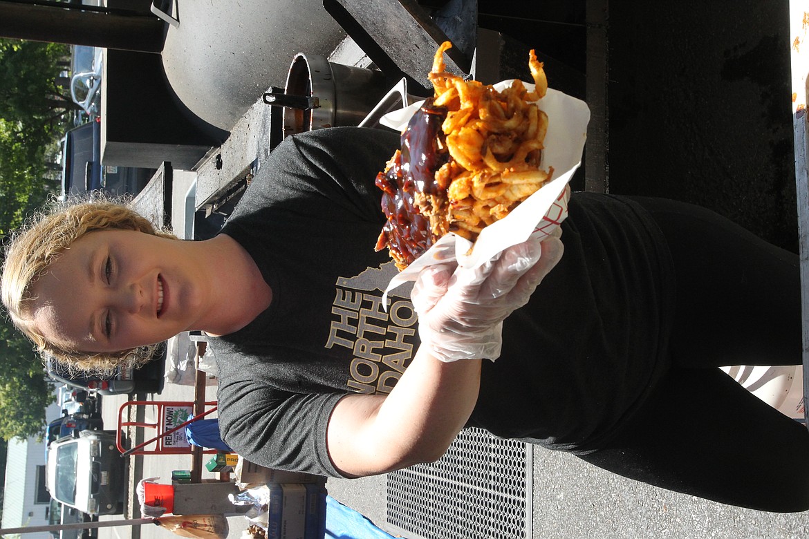 MITCHELL BONDS/Press
Karleigh Scott offers up a basket of &#145;Dirty Fries,&#146; curly fries with pulled pork and barbecue sauce, at the Country Snack Shack at the Post Falls Festival on Sunday afternoon.