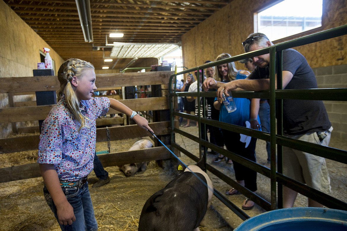 LOREN BENOIT/PressPheiffer Rosenberger showcases pigs she cares for while at the Rocking R Ranch's fourth-annual 4H fundraising event in Hayden.