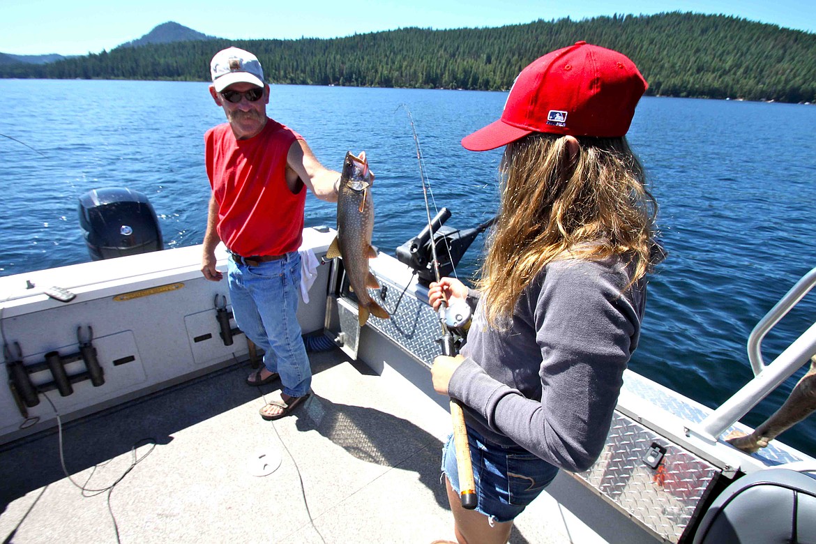 RALPH BARTHOLDT/Press
Fishing Guide Rich Lindsey hoists a small, mackinaw for a young angler Tuesday on Priest Lake.