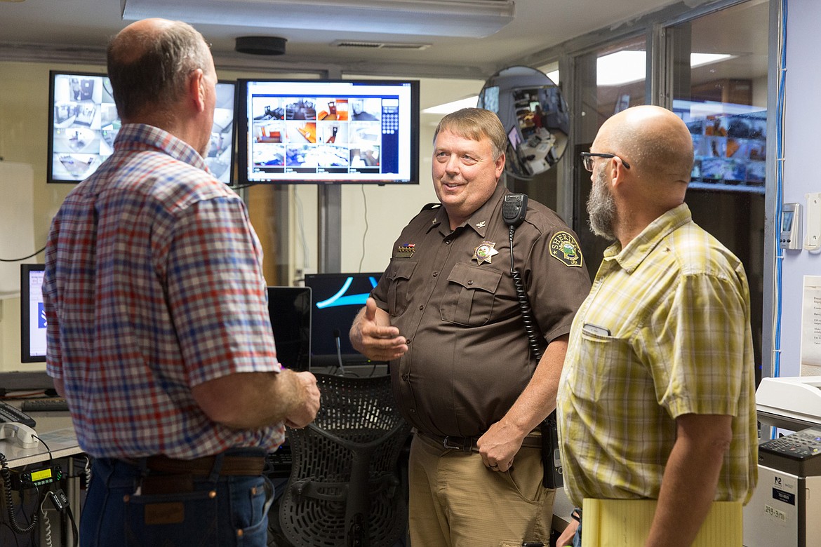 Lincoln County Sheriff Roby Bowe, center, discusses the county dispatch center with County Commissioner Mike Cole, left, and Jim Muskovich of Montana Association of Counties during a tour of the county jail on Wednesday, July 26, 2017. (John Blodgett/The Western News)