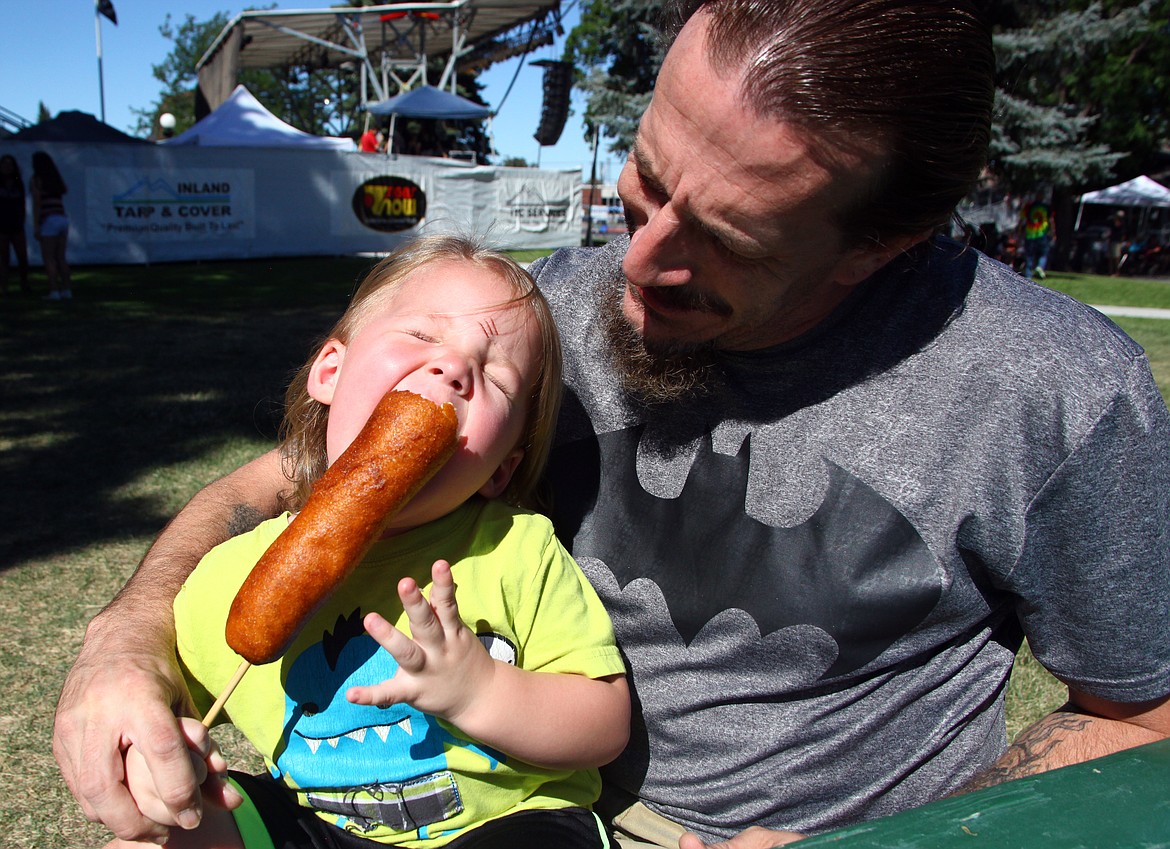 Rodney Harwood/Columbia Basin HeraldTwo-year-old Blaze Warren of Moses Lake gets a bite of his first corn dog from Shawn Warren during the Basin Summer Sounds Saturday afternoon.