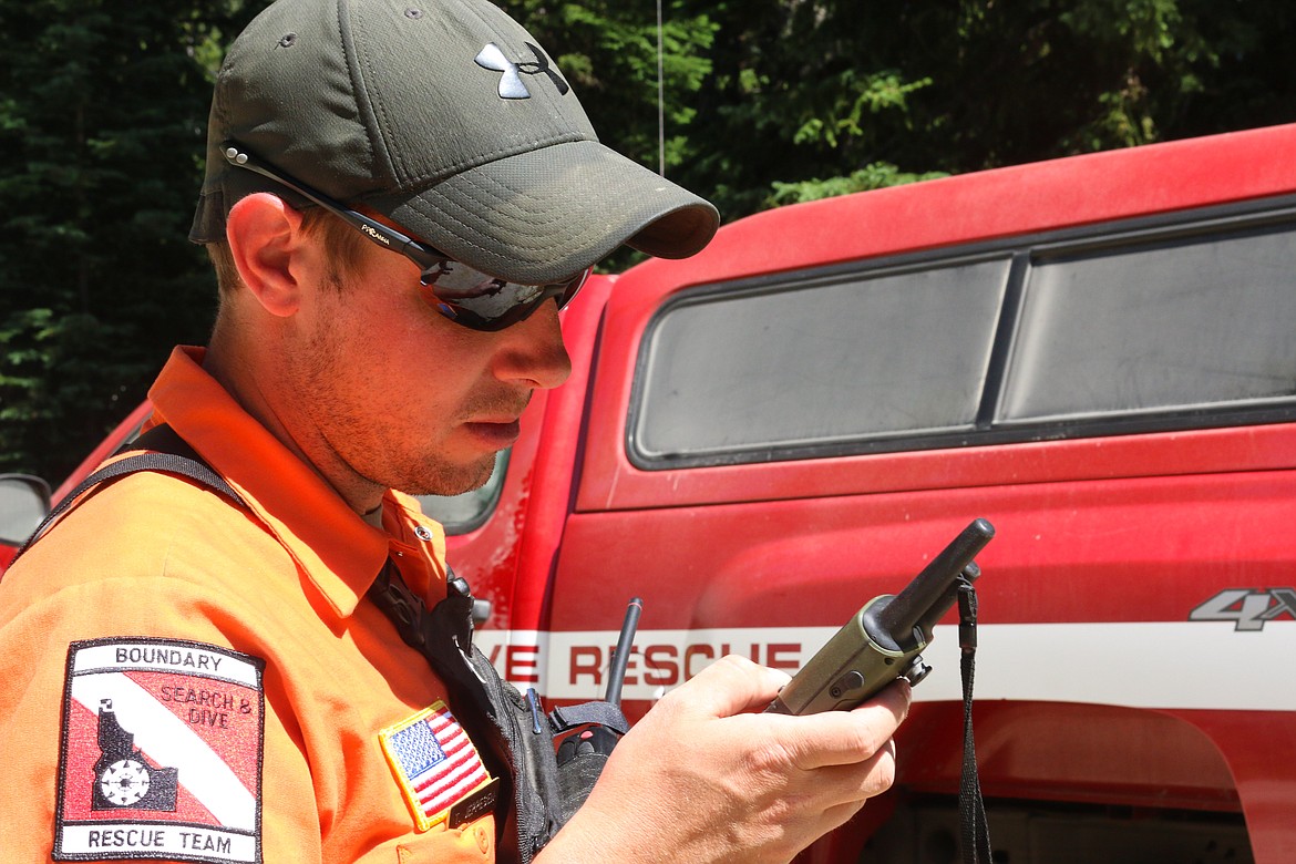 Search and Dive Rescue Team Vice Commander Tony Jeppesen sets a GPS unit for one of the rescue parties.