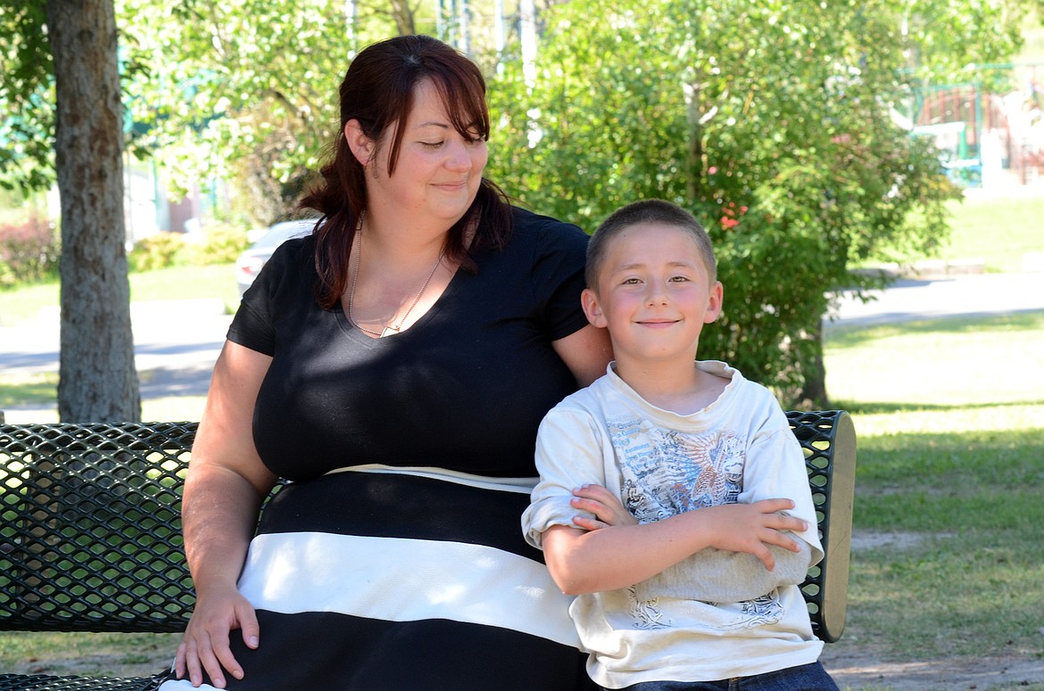 Jeremiah Hilliard, 7, with his mother Alisha Hilliard at Woodland Park in Kalispell on Friday, July 14. Jeremiah suffered serious burns after a boat explosion on Swan Lake last summer. (Matt Baldwin/Daily Inter Lake)