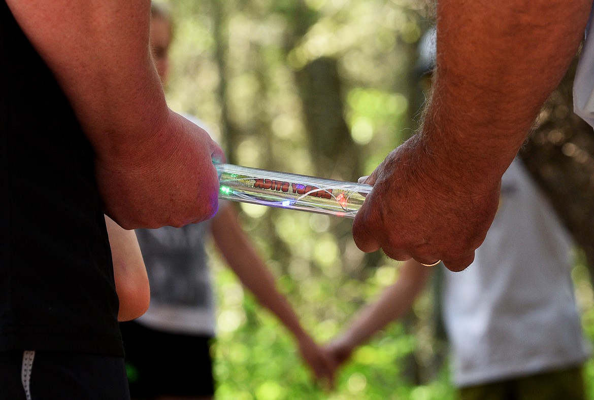 A tour group makes a circuit by joining hands at the House of Mystery on Thursday. (Aaric Bryan/Daily Inter Lake)