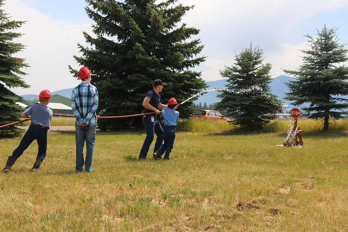 Photo by Mandi Bateman
Children, attending the anniversary of North Bench Fire District, shoot water at a sign.