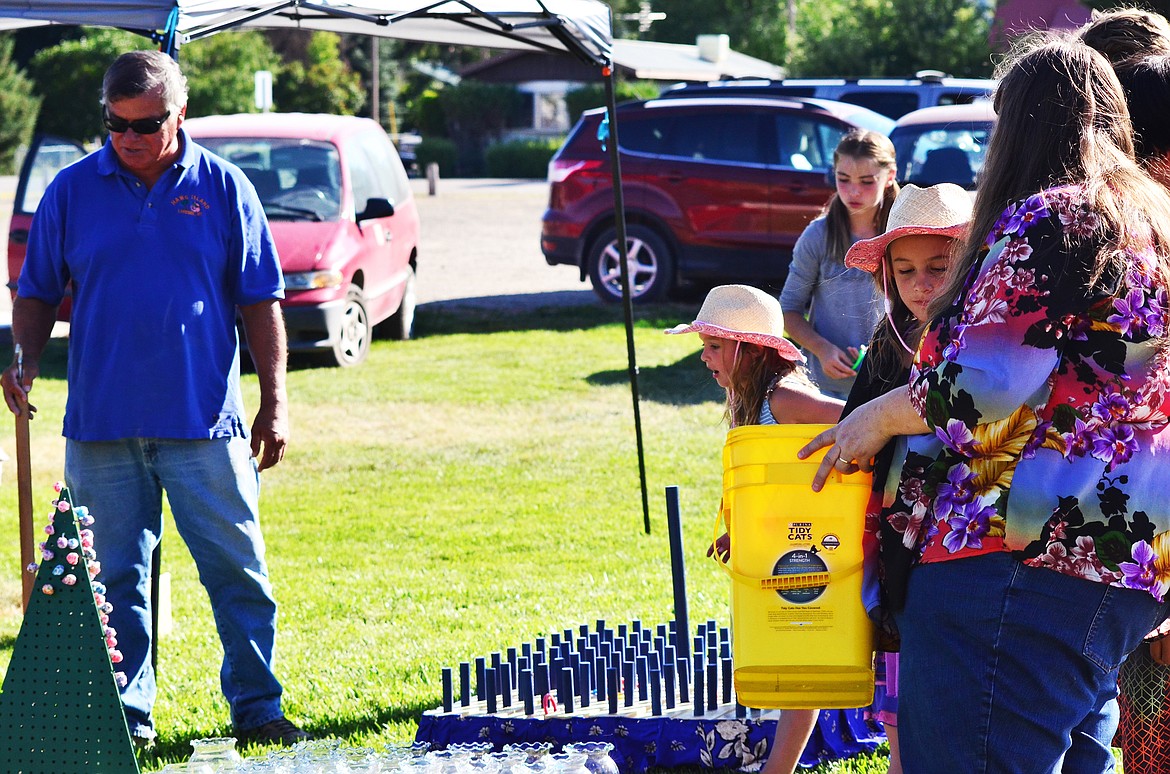 Local Lions Club President Dwayne Highcrane (left) and club secretary Anita Marsh (right) keep busy with the kids at the games booth.