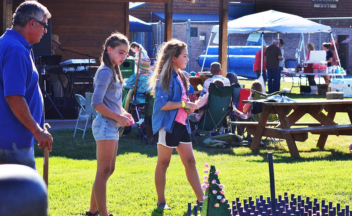 Local Lion Dwyane gives some encouragement to Marissa Young (left) and Emily Subatch (right) as they play the ring toss