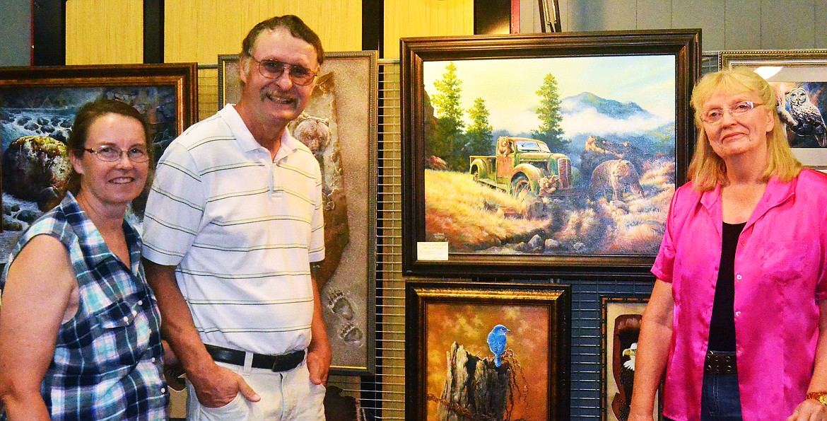 Tim &amp; Trudy Huls (left) of Corvallis MT, talk to Ma Brown Robbins (right) about her stunning painitings at the pop up gallery. (Erin Jusseaume/Clark Fork Valley Press)