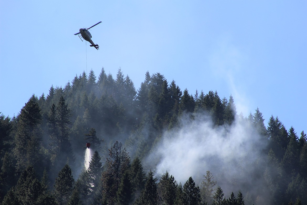Photo by CHANSE WATSON
A fire suppression helicopter drops water Sunday on the Big Creek fire, located southeast of the Sunshine Mine in the Silver Valley.