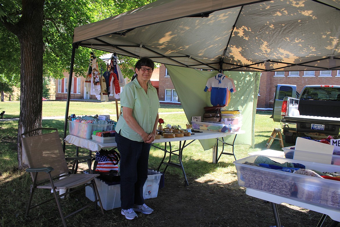 Ruth Johnson sets up her table at the Superior Farmers Market and displays knitted and woodworking items.