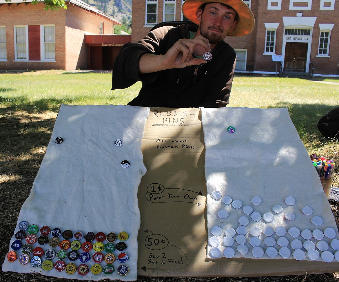 Evan Pierce holds up a rubbish pin he crafted from a bottle cap. Customers could also create their own pin if they were feeling artistic.