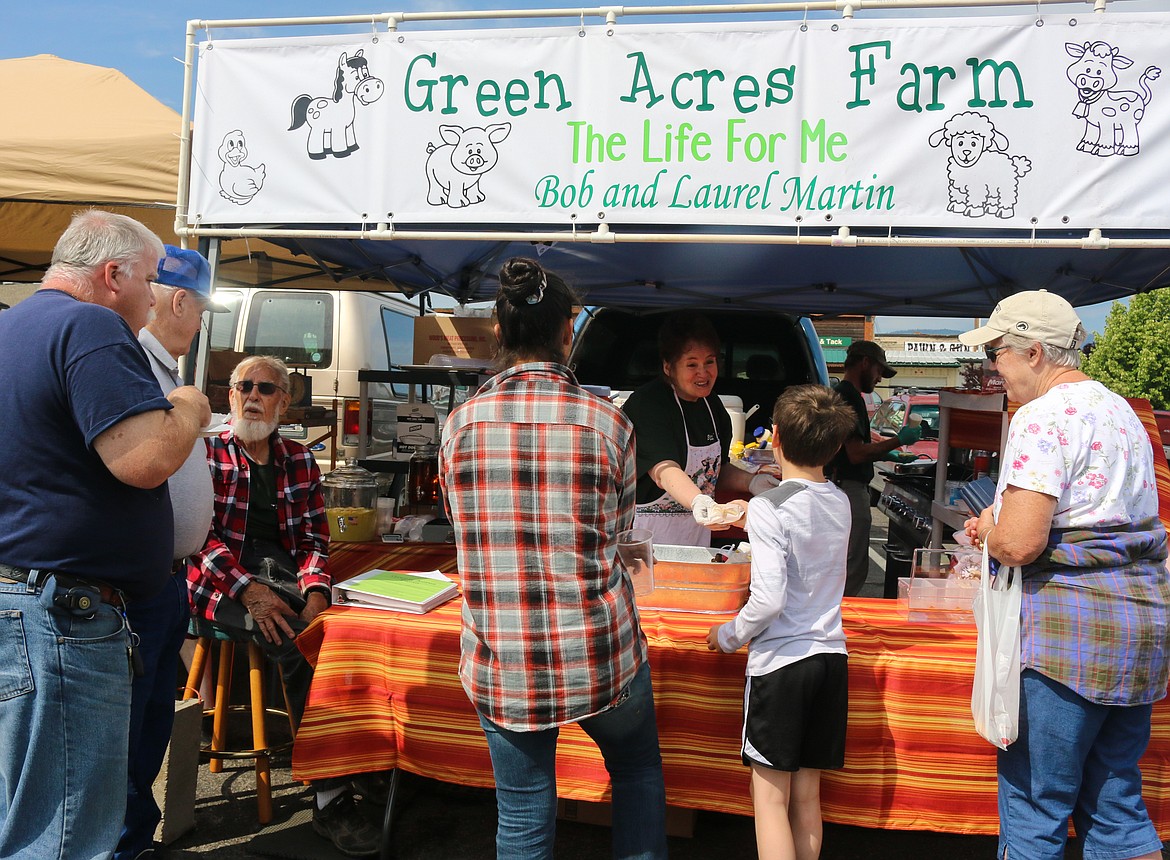 Photo by Mandi Bateman
&#147;Farmer Bob&#148; Martin turns 90 next month, so it seemed the perfect idea to open a brand new business. Farmer Bob, along with his wife &#147;Sizzling Laurel&#148; Martin and their nephew, David Kriedel, opened a booth at the Bonners Ferry Farmers Market, called Green Acres Farm, selling a variety of Bratwursts and custom &#147;McMartin&#148; Egg Muffins. Almost every item has ingredients that come from their farm and greenhouse, including the bacon, ham, sweet Italian sausage, and sliced Bratwurst options for the breakfast sandwiches. The family is as flavorful as the food, making for a fun experience for hungry farmers market goers.