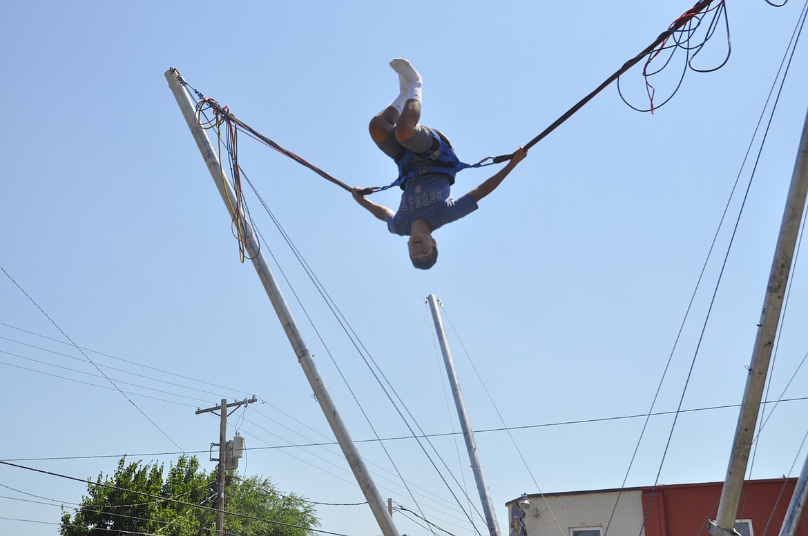 Elijah Taylor, 14, of Polson, completes one of four flips during a bungee session at the Flathead Cherry Festival Saturday. Taylor has done the bungee before and said it is a workout.