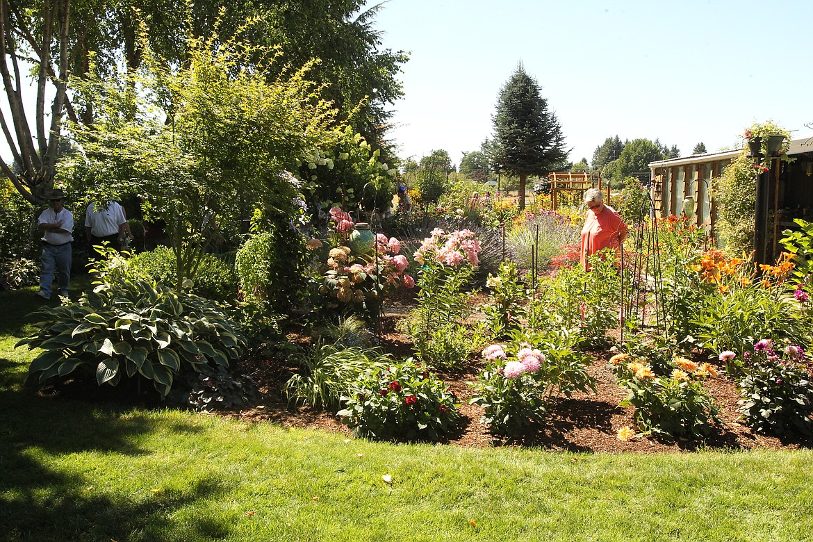 MITCHELL BONDS/Press
Guests browse through the greenery and colorful flowers (and veggies!) in Nancy and Steve Heffter&#146;s garden Sunday during the 20th annual Garden Tour.