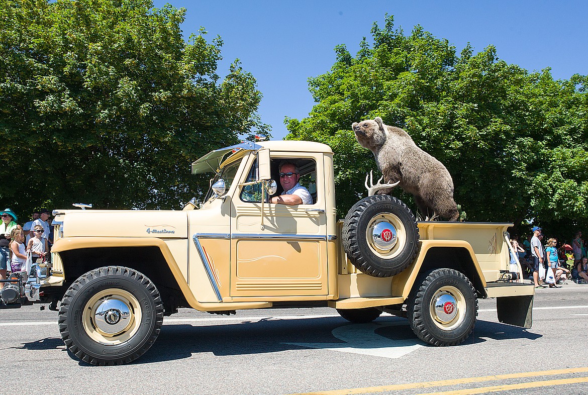 An old truck a grizzly bear.