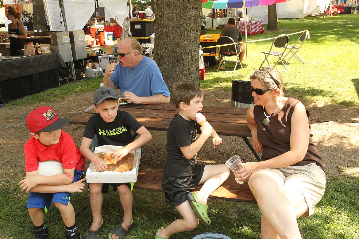 MITCHELL BONDS/Press
From front left, Isaac McCarty, 9; Brody Dobbs, 7; Elijah McCarty, 7; and Janelle McCarty of Snoqualmie, Wash., enjoy a Taste of Coeur d&#146;Alene with elephant ears, ice cream, and lemonade. In the background, Rick Bennett chows down on some frech fries.