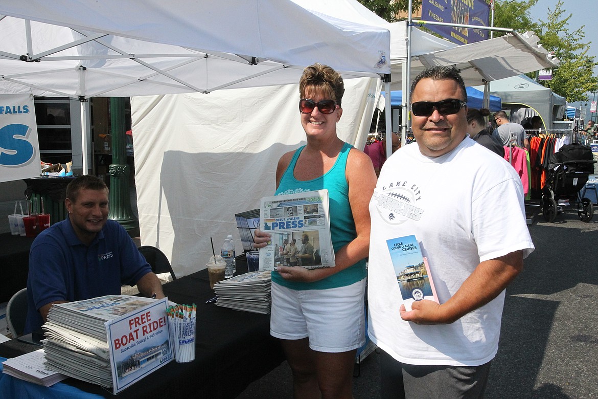 MITCHELL BONDS/Press
After some explanation from Chris Johnson, left, of the Coeur d&#146;Alene Press, Robert and Kim Torres subscribed to The Press at the Downtown Association&#146;s Street Fair on Sunday, making them some of our newest customers.